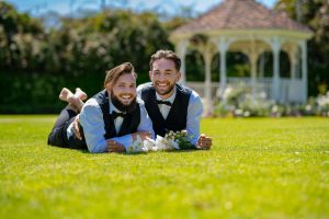 Male Grooms Smiling on Grass